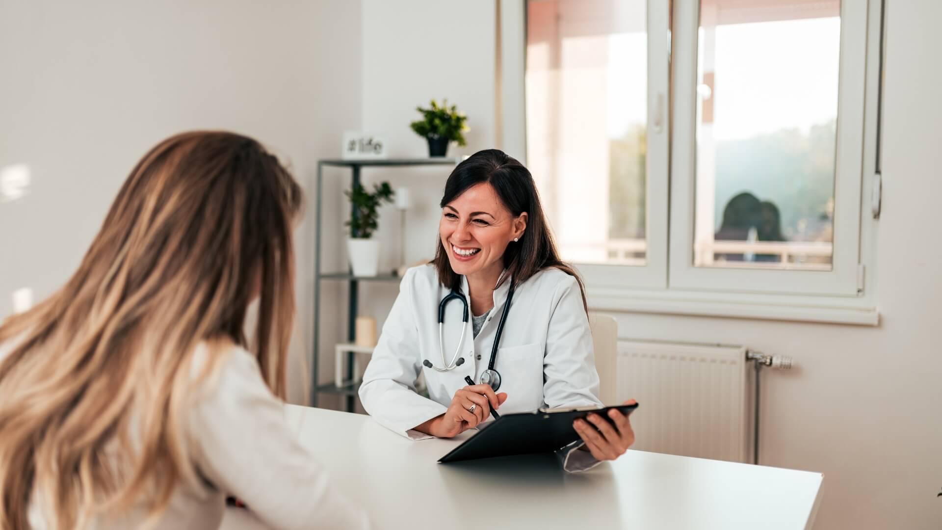 A doctor is talking to a patient in her office.